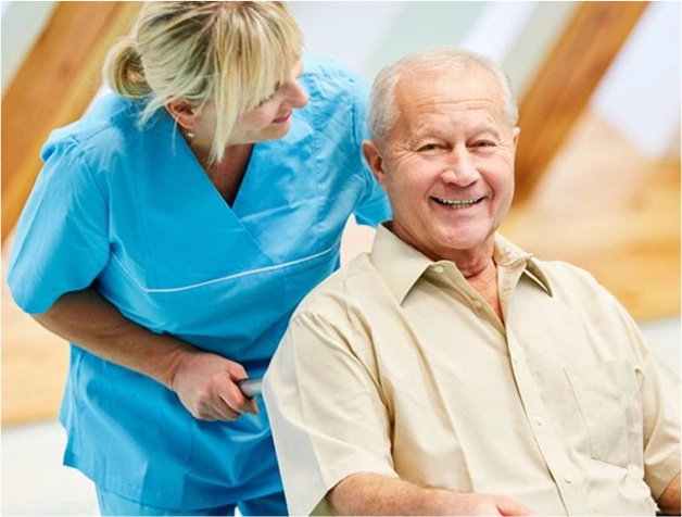 Elderly man with a walker smiling next to a supportive caregiver outdoors