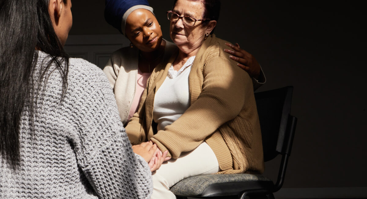Support, holding hands and senior woman in group therapy with women understanding, sharing feelings.